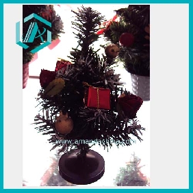 Cute small artificial green Christmas tree with different ornaments