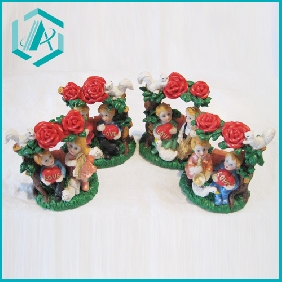 Wholesale resin gifts a boy holding "LOVE"-printed heart besides a girl playing instruments under a rose tree with a white swan
